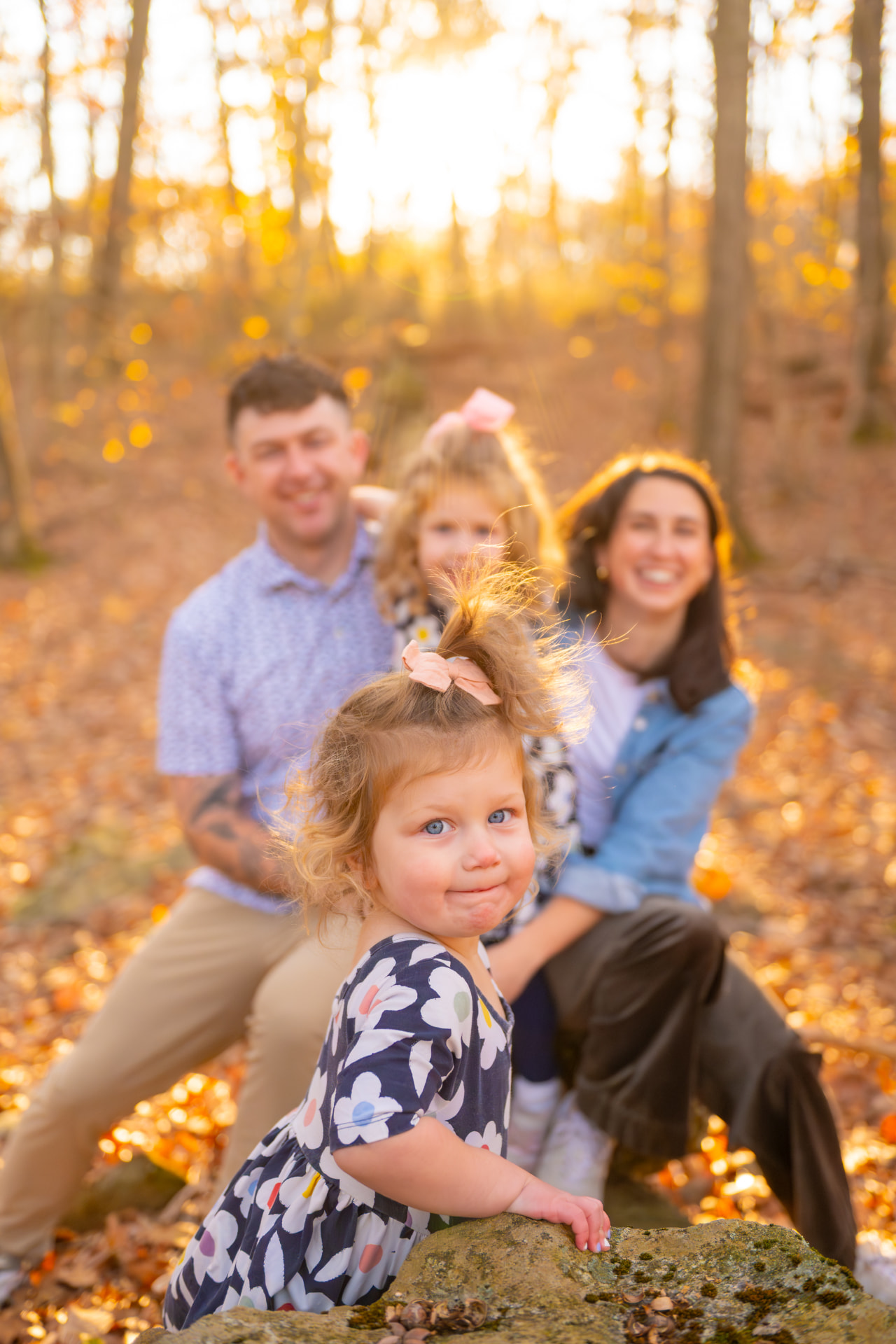 Chandler's family posing together outdoors with golden fall foliage in the background